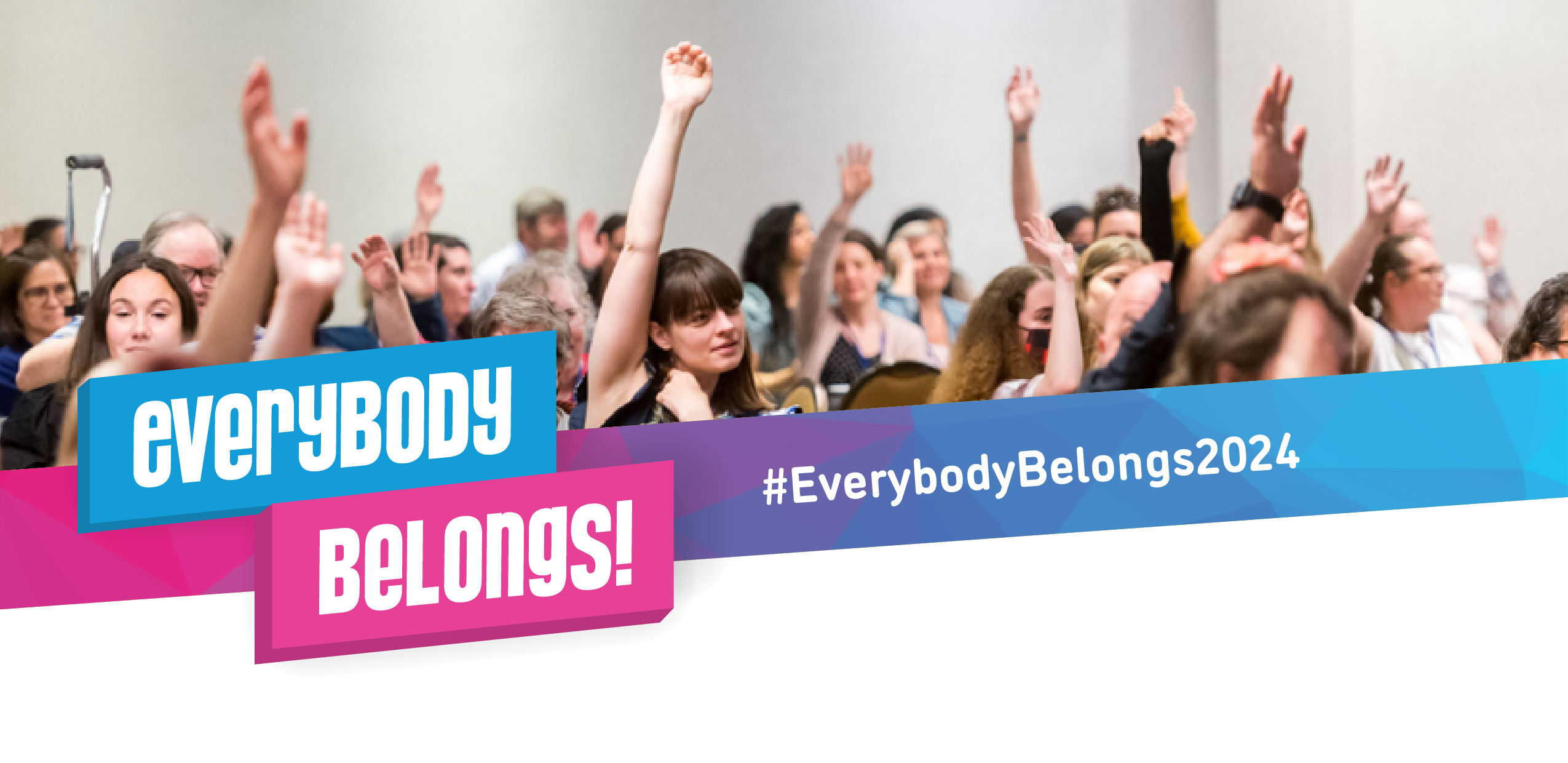 a large group of people with their hands up in a large room. Text reads: everybody belongs.