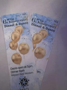 two tickets with image of gold balloons sitting on a table. The tickets read: 65th anniversary dinner and dance. Doors open at 5pm. Dinner at 6pm. Mission Best Western. MACL