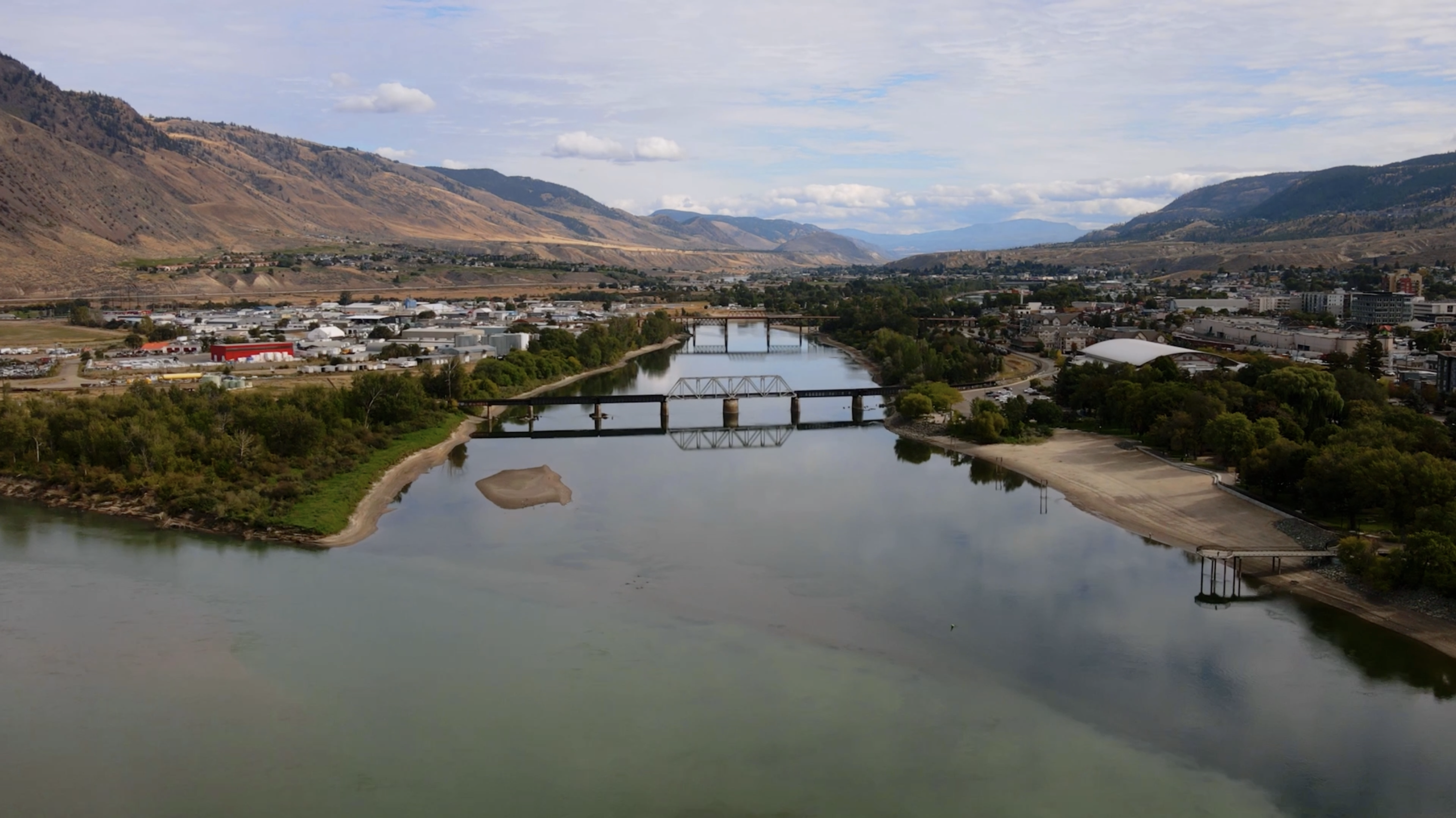 Kamloops, BC from the air – a bridge crosses a river with hills on either side.