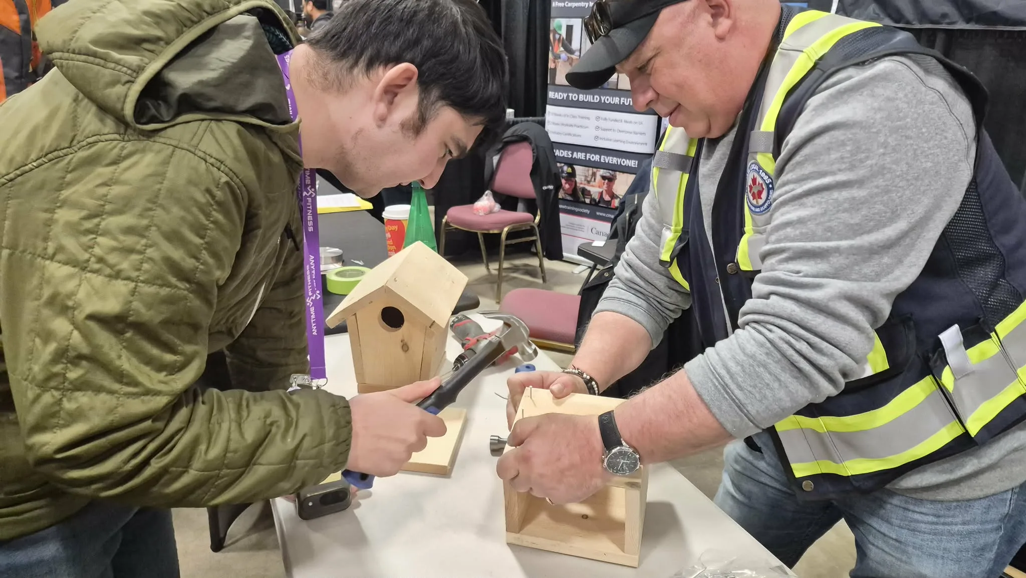 Two people working on building a birdhouse
