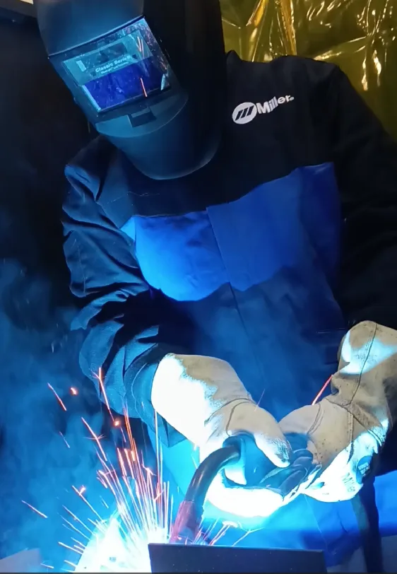 person in protective gear welding