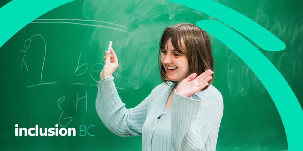 Women in front of a blackboard with her hand in the air